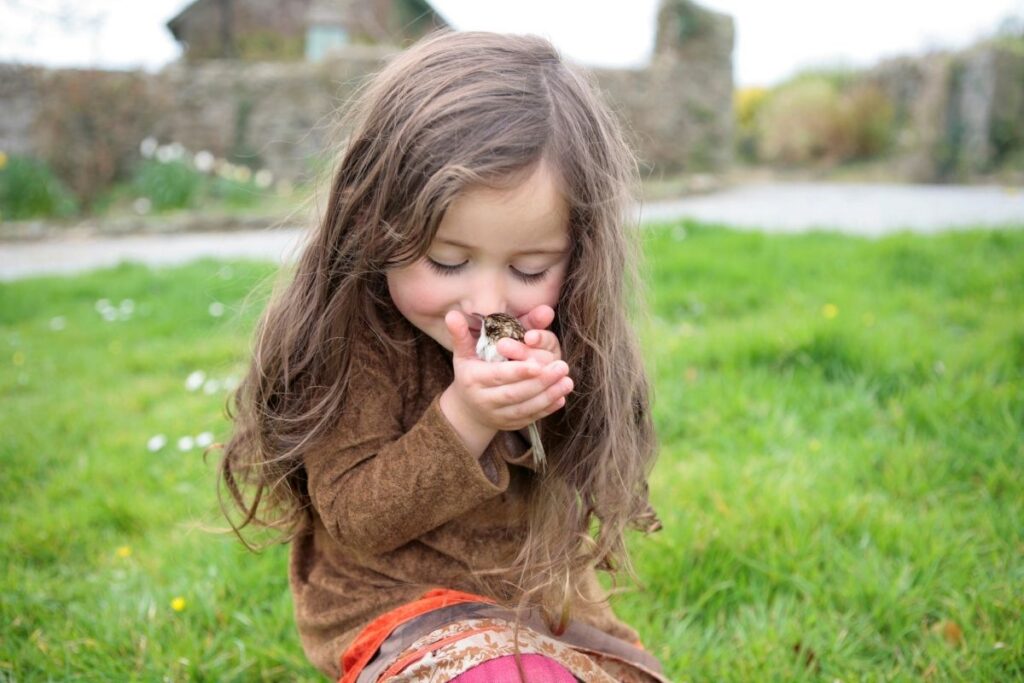 Little Girl Cuddling a Bird